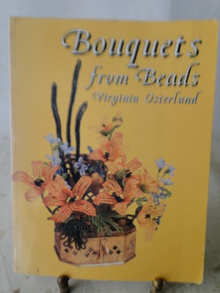 BOUQUETS FROM BEADS - VIRGINIA OSTERLAND - DOVER (NEW YORK, 2004) - EM INGLÊS, MUITO ILUSTRADO, 222pg, FORMATO: 21 x 27,5 cm - "Todo mundo aprecia um arranjo de flores artístico, mas os prazeres das flores frescas são muito fugazes. Este lendário manual revela os segredos para a criação de buquês de beleza duradouros com flores e folhagens frisadas. 'Bouquets from Beads' aplica os princípios e técnicas de um arranjo habilidoso aos estilos oriental e ocidental. Suas instruções completas e fáceis — BOUQUETS FROM BEADS