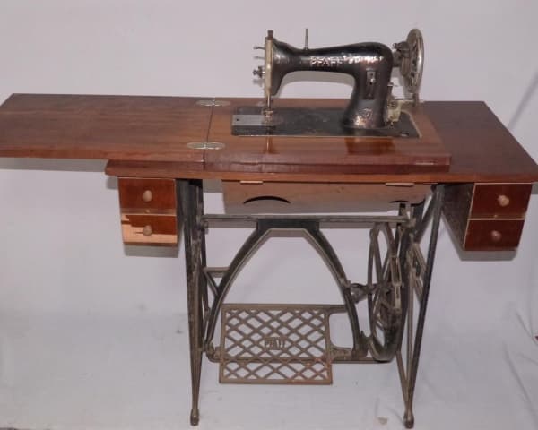 VINTAGE - Máquina de costura alemã PFAFF 31, pintada na cor preta com desenhos florais, tampo adaptado em MDP(aglomerado) revestido com laminas de mogno, 4 gavetas laterais, pés em ferro no estilo Art Déco pintado na cor preta com 4 rodas. Acompanha acessórios. Máquina e tapo com desgastes e pequenas faltas, porém funcionando. Med. fechada 80 x 91 x 43cm e aberta 78 x 123 x 100cm. — VINTAGE