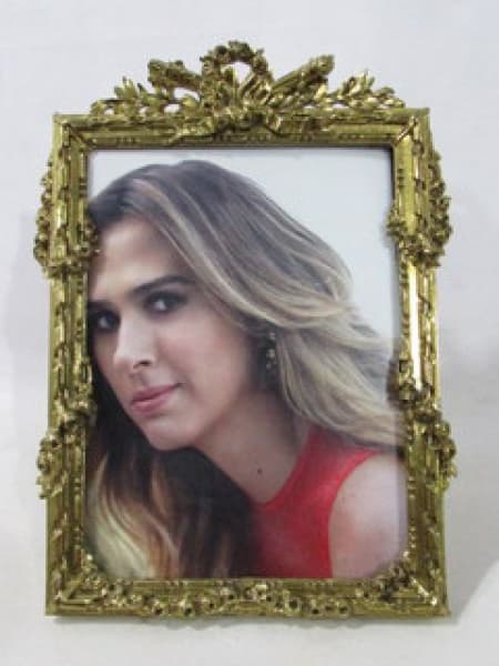 BRONZE - Um porta retratos confeccionado em bronze dourado, ricamente cinzelado, decorado com elementos vegetalistas em alto relevo. Medidas alt 23 cm x larg 16 cm. — BRONZE
