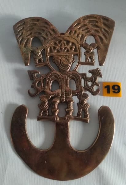 COLÔMBIA - Pectoral en forma de hombre-ave Escultura confeccionada em bronze proveniente da Colômbia, medindo 24x16cm. — COLÔMBIA