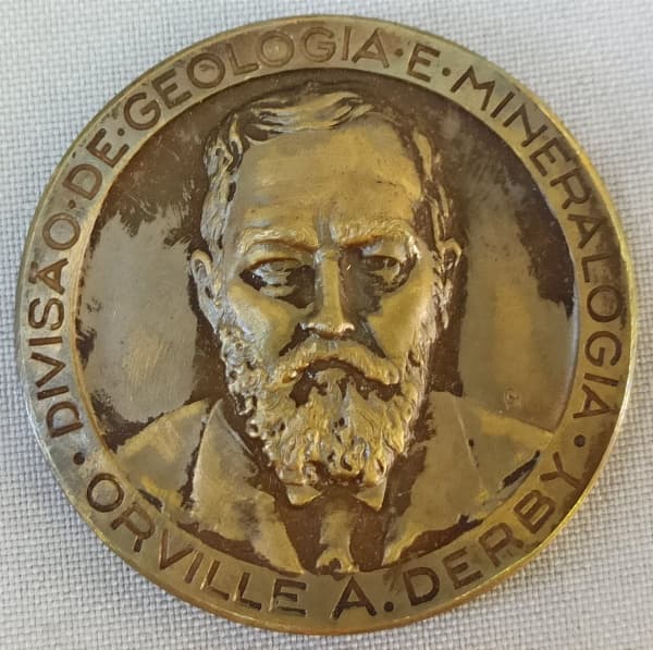 NUMISMÁTICA, uma (1) medalha circular comemorativa ao centenário do Nascimento de Orvillea Derby 1851 a 1951 Divisão de Geologia e Mineralogia, cunhada na Casa da Moeda do Brasil no Rio de Janeiro, confeccionada em bronze, medindo 50 mm diâmetro, muito bom estado de conservação ou mais. — NUMISMÁTICA