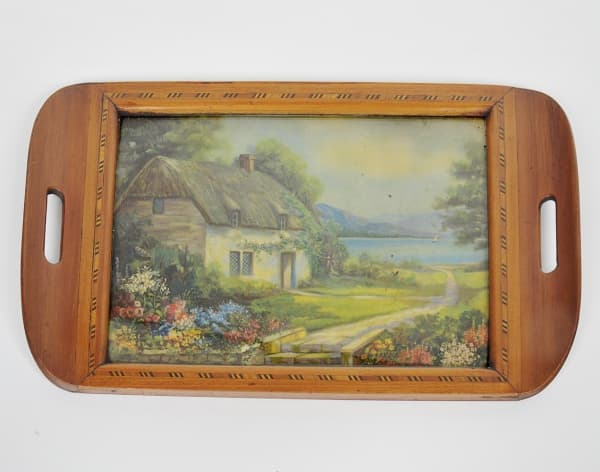 COLECIONISMO - Bandeja retangular confeccionada em madeira nobre marchetada, alças vazadas, parte central apresentando aquarela sobre papel retratando "Paisagem com casario". Proteção de vidro. Med: 48 x 29cm — COLECIONISMO
