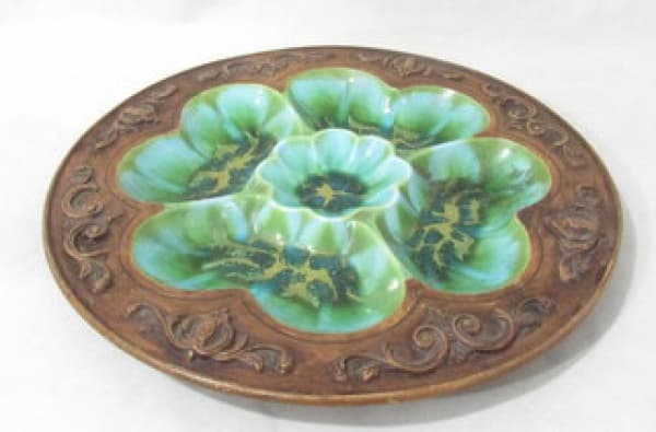 DIVERSOS - Belíssima petisqueira tailandesa confeccionada em terracota, interior com cinco divisórias vitrificadas em tons esverdeados com desenhos abstratos arrematados em dourado, bordas ricamente trabalhadas com florões, volutas e arabescos em relevo e esmaltada na cor marrom reproduzindo moldara em madeira. Medidas: 35,3 cm de diâmetro. — DIVERSOS