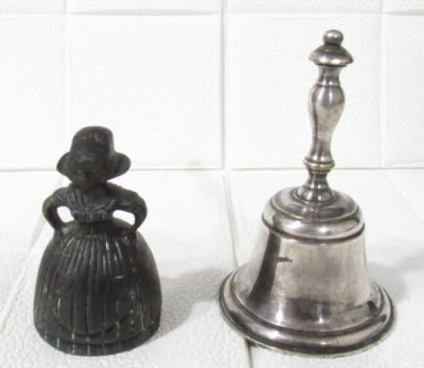 DIVERSOS - Lote contendo duas antigas sinetas, sendo uma em metal espessurado a prata, e uma em bronze ricamente cinzelado representando "holandesa". Med. maior: alt 10 cm/ diam 6,3 cm/ menor: alt 7 cm x diam 4,3 cm. — DIVERSOS