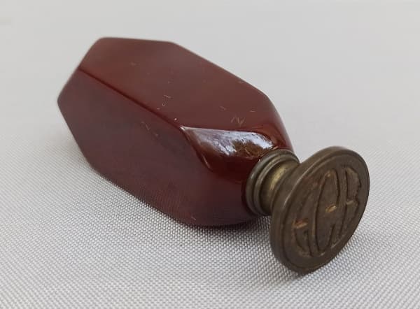 DIVERSOS, um (1) sinete em bronze com as iniciais EGB, cabo em baquelite ou símile na tonalidade amarronzada puxando para o vinho, medindo 7,5 cm altura. — DIVERSOS