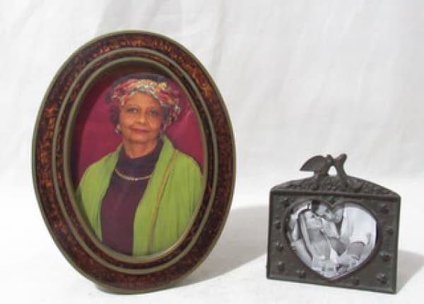 DIVERSOS - Dois (2) porta-retratos, sendo um ovalado em bronze, decorado com motivos abstratos em tons laranjas; e um em bronze decorado com flores finalizado com pombas. falta dos vidros. Medidas 20,5 x 16 cm e 10 x 10 cm. — DIVERSOS