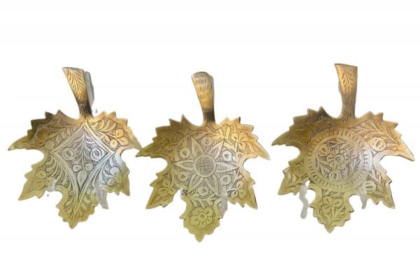 PAQUISTÃO - Portas copos em bronze paquistanês, representando folhas e decorados ao centro com motivo floral. Constam três unidades, sendo que dois possuem registro de origen na base. Mede 14,5 cm de comprimento. — PAQUISTÃO