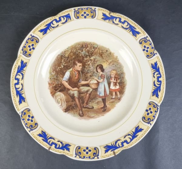 WOODS YVORY WARE, England - Prato decorativo em faiança inglesa com medalhão central de pintura com cena familiar, bordas onduladas. Suporte para parede. Manufatura no verso. Medindo: 27,5 cm. — WOODS YVORY WARE