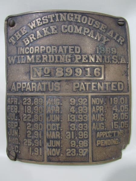 COLECIONISMO - Placa em bronze, data de 1869, utilizada em locomotivas a vapor nos EUA no século XIX e XX para identificar peças, fabricação da THE WESTINGHOUSE AIR BRAKE COMPANY, Nº de série 89916, patenteada. Possui falta em um dos vértices. Medida 17 x 15 cm — COLECIONISMO