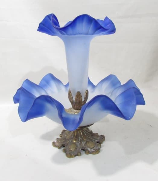 BRONZE - Peça mista entre fruteira e floreira em pasta de vidro na tonalidade azul moldada em ondulações com frisos no feitio de flores, com base e suporte em bronze, pés em acantos decorados com gomos e folhagens. Medida 30 x 27 cm — BRONZE