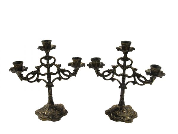 BRONZE, Par de candelabros para 3 velas confeccionados em bronze, cinzelado por arabescos e volutas em vazados, bobeche no feitio de flor, apoiada sobre base recortada com elementos vegetalistas em relevo, medindo 23x23cm. — BRONZE