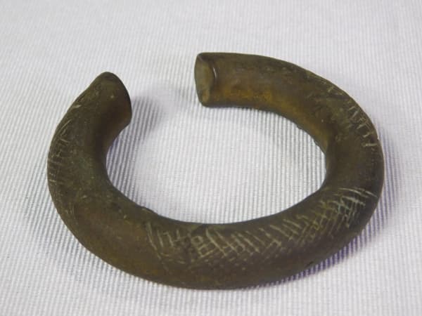 COLECIONISMO - Manilla em bronze, moeda comercial da África Ocidental, incluindo tráfico de pessoas escravizadas, século XVIII / XIX. Med 7 x 7cm.Manilla termo europeu paro o dinheiro- pulseira. Usada entre o século XVI até sua abolição em 1949, elas foram utilizadas para compra de noiva, gado e posteriormente de escravos africanos pelos europeus. — COLECIONISMO