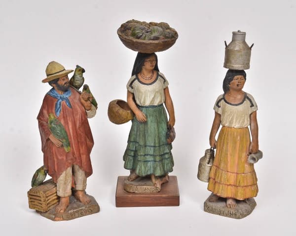 SERAFN MARSAL (PARAGUAI, 1862-1956). "Loritero, Yvá Vendejhá e Gamby Jhe", duas esculturas em barro cozido policromado, produzida com argila do Rio Picolmayo - Assunção. Assinadas e tituladas em Guarani. Alts.: 23cm, 22cm e 19cm. (Uma figura com chapéu colado e base quebrada). — SERAFN MARSAL