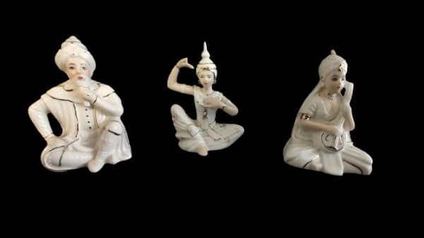 MATI PIERO DESIGNER IN SPAIN - Trio de peças em porcelana branca, com pintura artesanal na tonalidade dourada representando músicos. Obs: Uma das peças com a cabeça quebrada e colada. Medidas da maior: 10 cm de altura, 4 cm de largura e 8 cm de comprimento. — MATI PIERO DESIGNER IN SPAIN