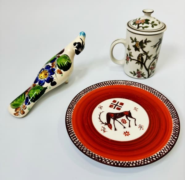 MÉXICO - Lote composto por 2 esculturas em faiança no formato de ave acompanha o lote prato decorativo com pintura feita à mão e caneca decorada por flores, pássaros e ramagens.. Mede 21cm e 19cm e 14cm. — MEXICO