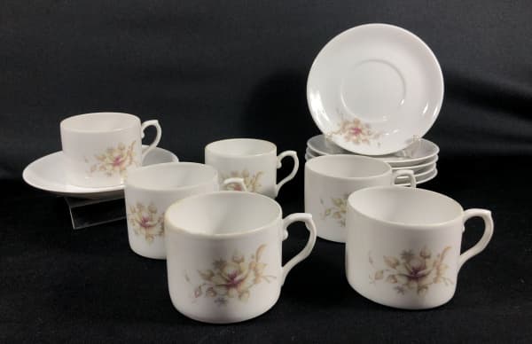 DECOR EVA, PORTUGAL - Conjunto com 6 xícaras para café, confeccionadas em porcelana branca, apresentando belo trabalho em desenho floral. Ao fundo, contém selo de manufatura: Decor Eva Portugal. As peças apresentam pequenos sinais de desgastes nas bordas, conforme fotos. Medidas xicaras: 7 cm de diâmetro x 6 cm de altura. Pires: 14,5 cm de diâmetro. — DECOR EVA